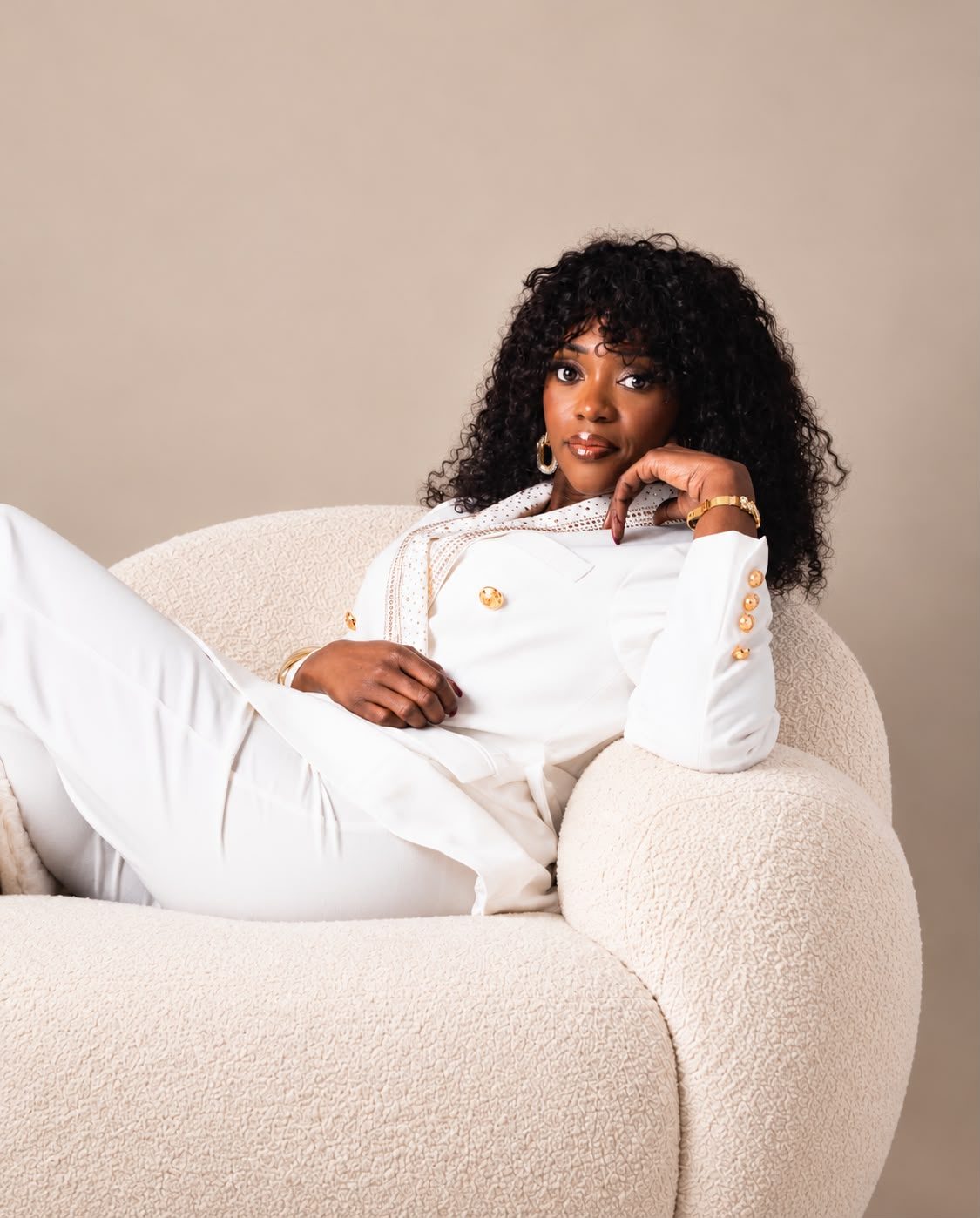 Feza Mushobekwa allongée dans un fauteuil, le regard vers l’objectif
